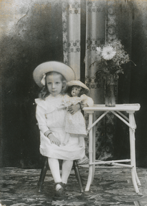 876212 Portret van Rika Kool uit de Korte Viestraat in Wijk C te Utrecht, met een pop in de arm in een fotostudio. Haar ...